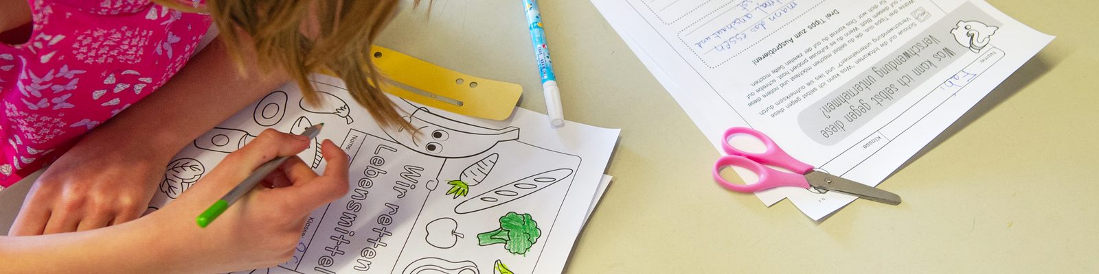 Kinder bearbeiten ein Arbeitsblatt zur Haltbarkeit von Lebensmitteln